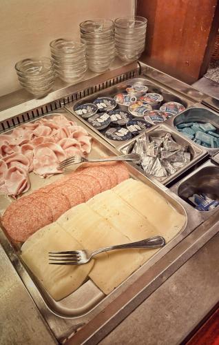 a counter with a tray of food with a fork and meat at Hotel Villa Igea in Alassio