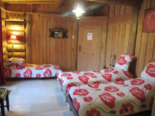 a room with two beds with red and white sheets at La Fuste des Garceaux in Orconte