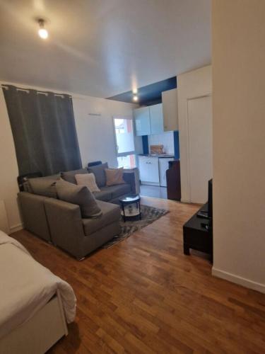 un salon avec un canapé et une table dans l'établissement Appartement entier Saint-Denis, stade France, à Saint-Denis