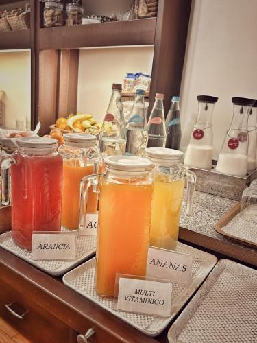 a bunch of jars filled with different types of juice at Hotel Villa Igea in Alassio