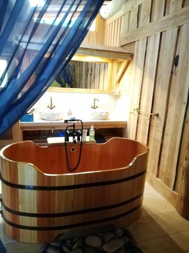 a wooden tub in a bathroom with two sinks at La Fuste des Garceaux in Orconte