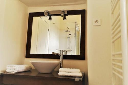 une salle de bain avec un lavabo et un miroir dans l'établissement Maison de caractère spacieuse et confortable, grand jardin , superbes vues, à Castello-di-Rostino