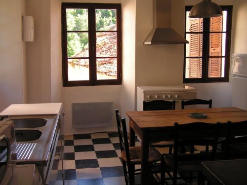 une cuisine avec une table et des chaises dans une pièce dans l'établissement Maison de caractère spacieuse et confortable, grand jardin , superbes vues, à Castello-di-Rostino