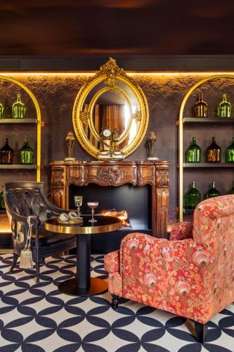 a living room with a fireplace and a table and a chair at Château Jeanne & The Forest - Château de Montvillargenne in Gouvieux