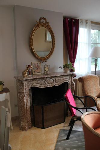 un salon avec une cheminée et un miroir dans l'établissement gîte Joséphine, à Attin