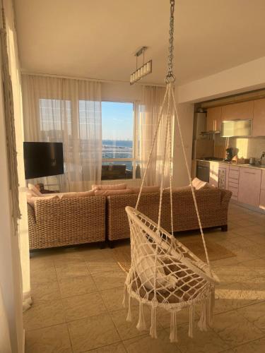 a room with a hammock in a living room at Voyage Apartment Mamaia in Mamaia