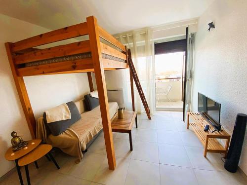 Cette petite chambre comprend des lits superposés et un canapé. dans l'établissement Agréable studio 7 au penon proche plages, à Seignosse