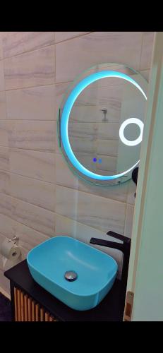 a bathroom with a blue sink and a mirror at White Luxury Villa Apartments &Hot Tab in Durrës