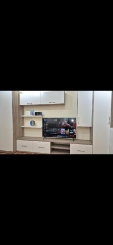 a living room with a television and white cabinets at White Luxury Villa Apartments &Hot Tab in Durrës