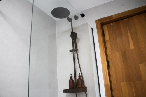 a glass shower with two bottles on a wall at Casa Kiwi in Algeciras