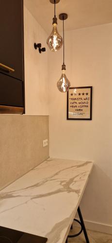 a kitchen with a table and two lights at Casa Kiwi in Algeciras