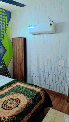 a bedroom with a bed and a light on the wall at Hotel paris in Mohali