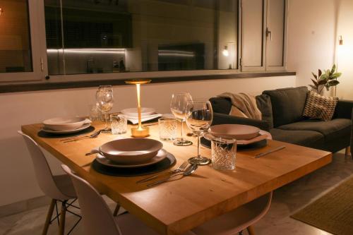 a wooden table with plates and wine glasses on it at Casa Kiwi in Algeciras