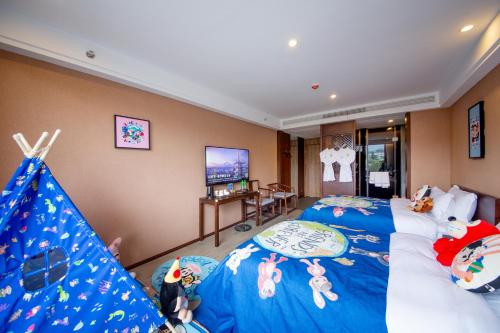 張家界市にあるXinwei Hotelのベッド2台とテレビがあるホテルの部屋