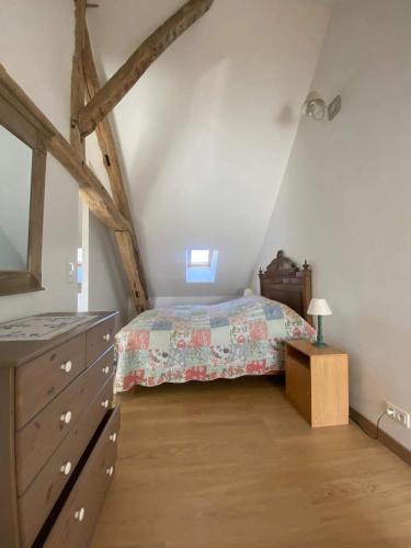 - une chambre mansardée avec un lit et une commode dans l'établissement L'Atelier de Pierre 1-Bed Cottage in Pousseaux, à Pousseaux