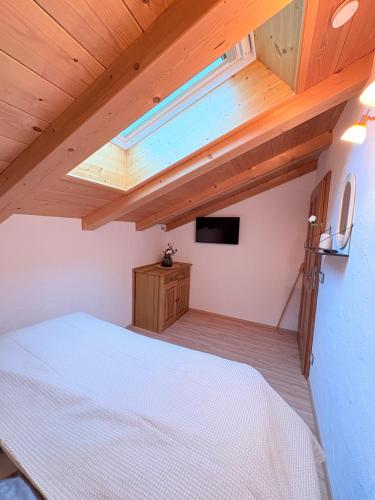 a bedroom with a white bed and a wooden ceiling at Ferienwohnung Datzmannlehen mit traumhaften Bergblick und Sauna in Ramsau