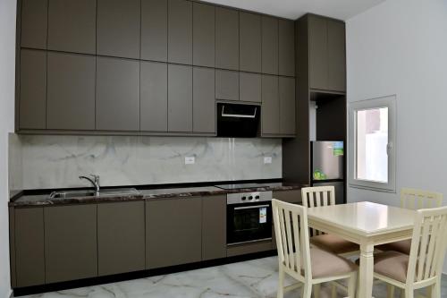 a kitchen with a table and a table and chairs at Ferienhaus Qelia in Durrës
