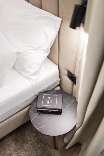 a table with a clock on it next to a bed at De Pusterla Luxury Rooms in Zadar
