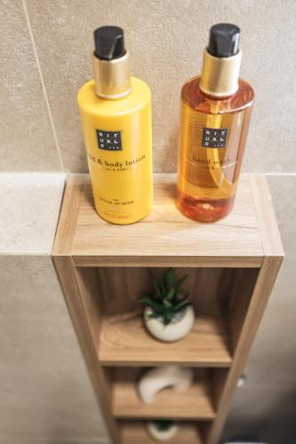 two bottles of liquids sitting on a wooden shelf at De Pusterla Luxury Rooms in Zadar