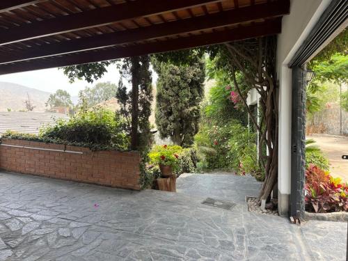 a patio with flowers and a brick wall at Casa Shanti in Cieneguilla
