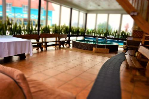 a building with a pool and a table and benches at Atostogų namas su baseinu, jacuzzi ir pirtimi in Klaipėda