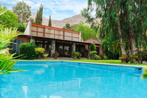 a house with a swimming pool in front of a house at Casa Shanti in Cieneguilla