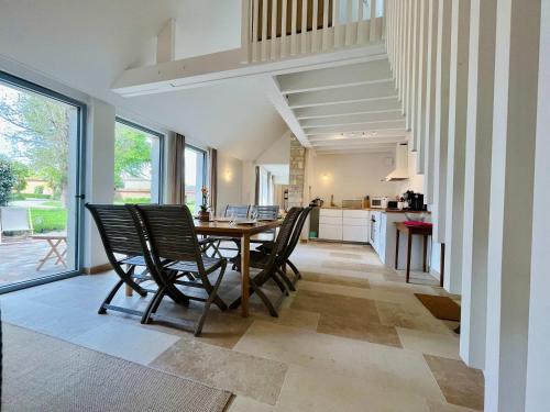 a kitchen and dining room with a table and chairs at La maison de l'Orangerie - Charm & comfort in the very heart of Carentan in Carentan