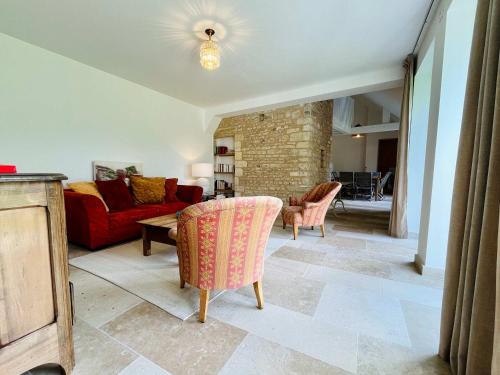 a living room with a couch and a table and chairs at La maison de l'Orangerie - Charm & comfort in the very heart of Carentan in Carentan