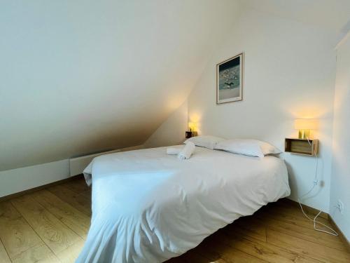 a white bed in a room with two lamps at La maison de l'Orangerie - Charm & comfort in the very heart of Carentan in Carentan