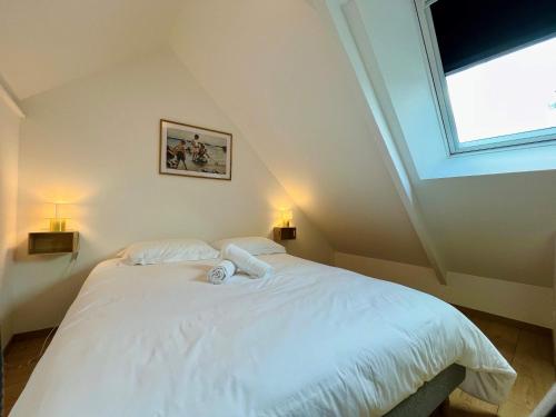 a bedroom with a large white bed with a window at La maison de l'Orangerie - Charm & comfort in the very heart of Carentan in Carentan