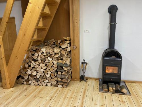 a pile of fire wood in a room with a stove at Apartma Confine in Rateče
