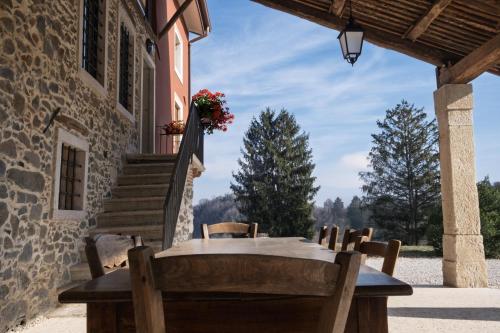 a table and chairs on the porch of a house at MASARI ALLA CASA ROSSA Vineyard guest house in Brogliano