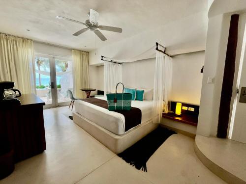 a bedroom with a bed and a ceiling fan at Cabanas Tulum- Beach Hotel & Spa in Tulum