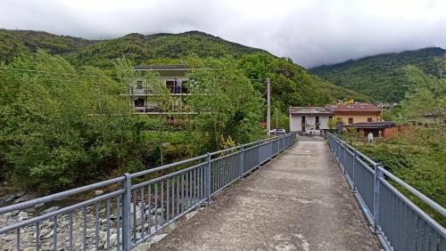 a bridge over a road with mountains in the background at Casa Stella Baita Valle Viva in Roure Turin