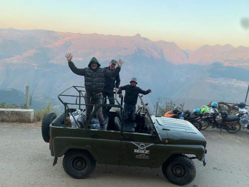 three people are standing in the back of a jeep at Lotus Premium Lodge - Lotus Group Tours in Ha Giang