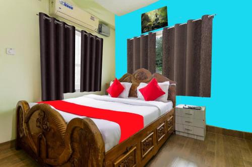Un dormitorio con una cama grande con almohadas rojas. en A Golden Puri Eco Resort, en Puri