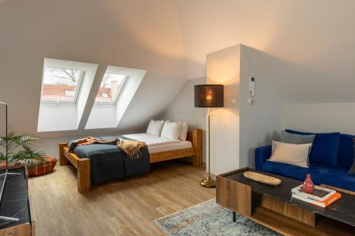 a bedroom with a bed and a blue couch at Trevi Apartments Tychy in Tychy