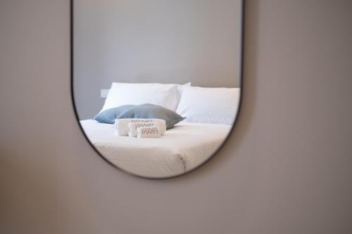 a mirror reflecting a bed with two pillows at Palazzo Pisani - Bari in Bari