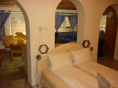 a bed in a room with an arched doorway at R1 Rolléder Apartman-ház in Siklós
