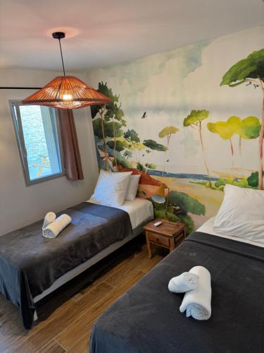 two beds in a room with a painting on the wall at Villa Arbevhio in Bonifacio