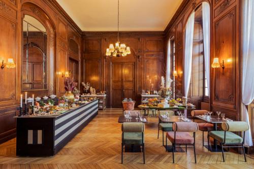 a restaurant with wooden walls and tables and chairs at Château Jeanne & The Forest - Château de Montvillargenne in Gouvieux