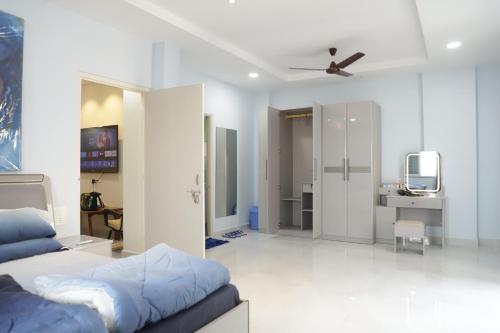 a bedroom with a bed and a desk and a tv at V & U Homestay Sadar in Nagpur