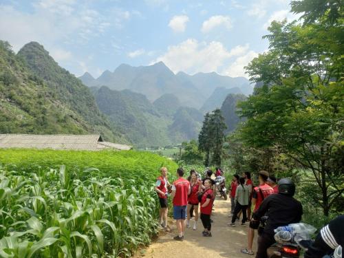 a group of people walking down a dirt road at Lotus Premium Lodge - Lotus Group Tours in Ha Giang