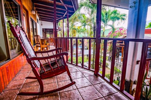 a rocking chair sitting on the porch of a house at Poshtel Arenal in Fortuna