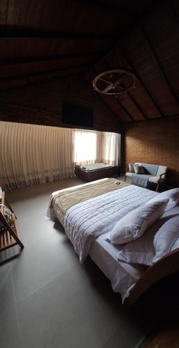 a bedroom with a large bed and a window at Chalé HOSPEDAGEM in Rio Bananal