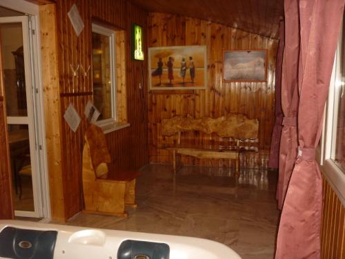 a bathroom with a tub in a room with wooden walls at R1 Rolléder Apartman-ház in Siklós