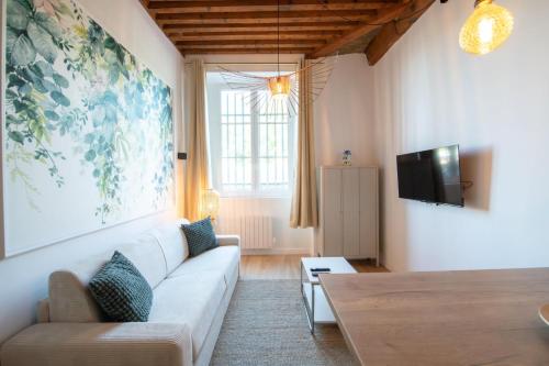 un salon avec un canapé blanc et une télévision dans l'établissement Lassagne - 2, à Lyon