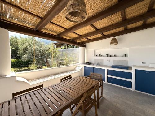 a kitchen with a wooden table and blue cabinets at Case a Malfa - Alba & Rosina, Isola Salina in Malfa