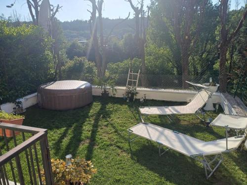 a yard with two chairs and a hot tub at Villa Santa Maria - Giardino privato - vista fiume in Sandra