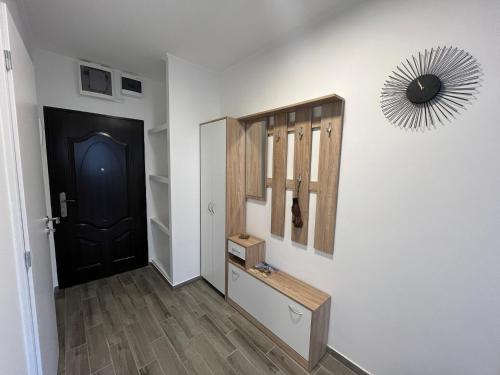 a hallway with a black door and a mirror at Beszterce Apartman in Salgótarján